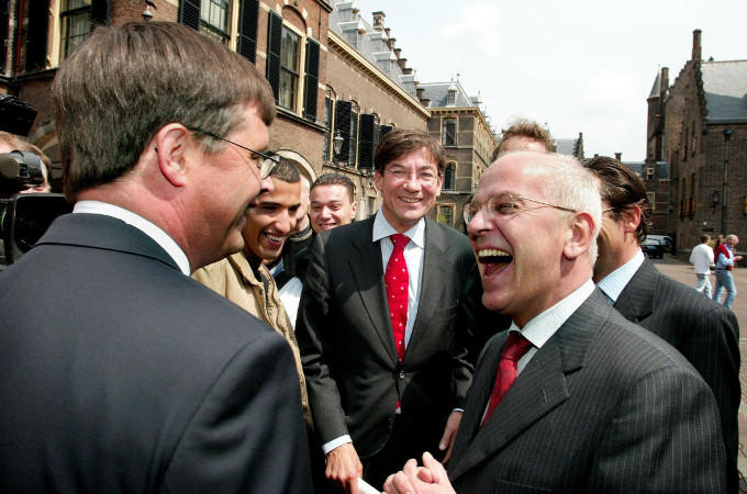VVD-onderhandelaar Gerrit Zalm (rechts) en premier Balkenende (links) feliciteren elkaar op het Binnenhof met het regeerakkoord. In het midden: Maxime Verhagen 