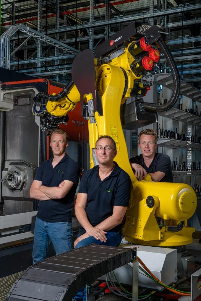 Compagnons Ruud Appel, Gem Bot en Dennis Oud bij een van de draaimachines die met een robot worden aangestuurd. Achter Dennis Oud gereedschappen die de robot in de machine kan zetten