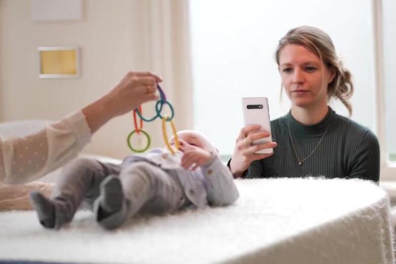 Een fysiotherapeut gebruikt de app Skully Care om een babyhoofdje te meten
